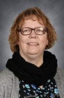 Picture of a person with a grey top and a scarf